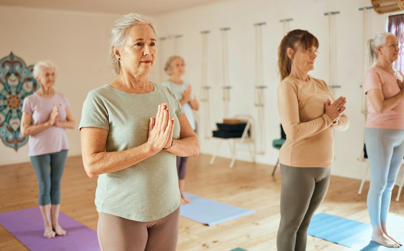 Yoga, meditation and fitness with a senior woman in an exercise class for holistic wellness or ment